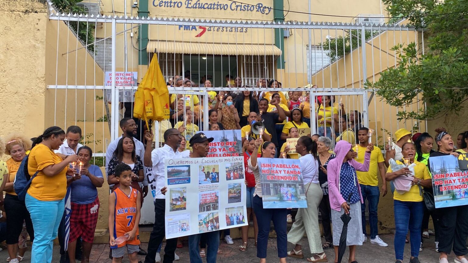 Cientos de padres y madres de estudiantes con consignas, vestido de amarillo,  velas encendidas y pancartas exigieron la noche de ayer martes al gobierno, a través del Ministerio de Educación, la terminación del pabellón de la secundaria de la Escuela Parroquial  Cristo Rey, obra que lleva más de tres años  en construcción en el sector del mismo nombre, en el Distrito Nacional.